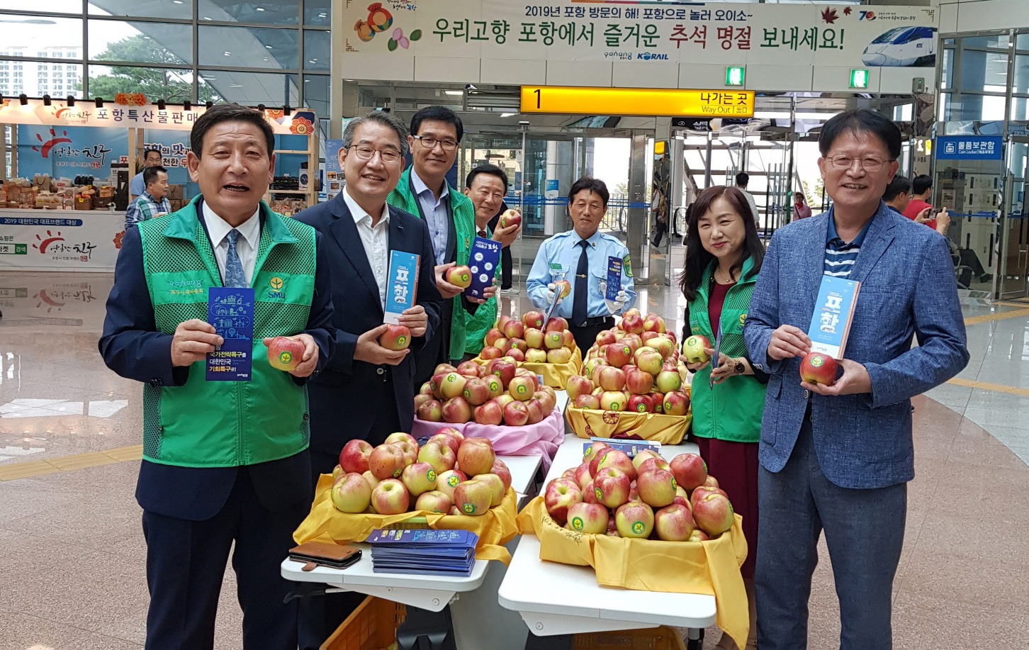 최현욱 포항시새마을회 회장을 비롯한 새마을회 지도자들이 귀성객들에게 나눠 줄 사과를 들고 있다.