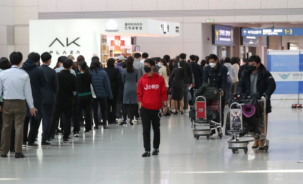 20일 오후 인천국제공항 1터미널 약국에서 상주직원들이 공적 마스크를 구매하기 위해 줄을 서 있다. 연합