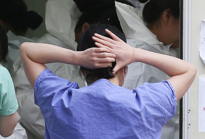 대구 중구 계명대학교 대구동산병원에 한 의료진이 머리를 질끈 묶으며 방호복 착의실로 이동하고 있다. 박영제기자 yj56@kyongbuk.com