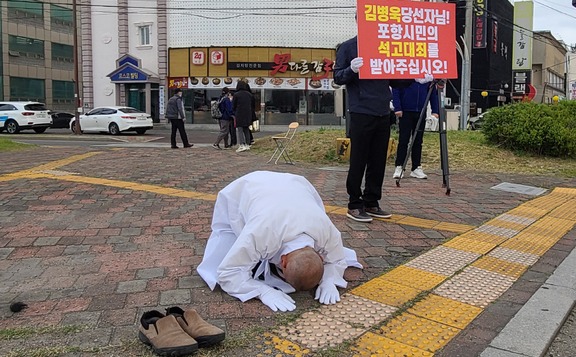 17일 오전 7시 포항 형산오거리에서 더불어민주당 소속 이재도 경북도의원이 석고대죄 행사에서 큰절을 하고 있다.