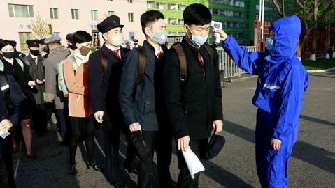(평양 AP=연합뉴스) 신종 코로나바이러스 감염증(코로나19) 사태로 방학 연장 조치를 취했던 북한 평양의 김책공업종합대학이 22일 개학한 가운데 재학생들이 마스크 차림으로 등교하며 체온 검사를 받고 있다.