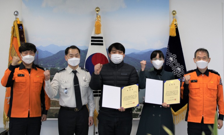 지난달 25일 김천우체국 직원 정승화(가운데)·김하나(왼쪽 네번째)씨가 박경욱(왼쪽 두번째) 김천소방서장으로부터 표창을 받고 있다. 김천소방서 제공