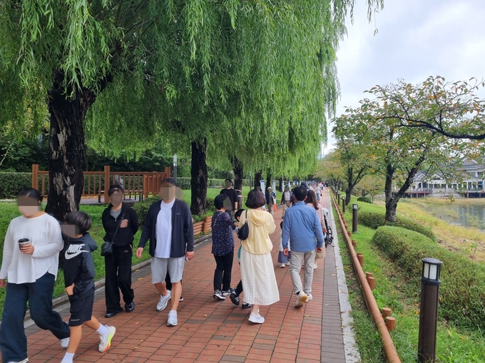 ▲ 추석연휴 이틀째인 4일, 흐린 날씨에도 불구하고 보문관광단지를 찾은 수많은 관광객들이 보문호수를 띠라 조성된 산책길을 걷고 있다.  황기환 기자