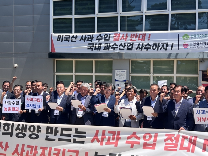▲ 조용일 금성농협 조합장(앞줄 왼쪽 두번째)을 비롯한 농협 관계자들이 7월 29일 경북 상주시 한국사과연합회 앞에서 ‘사과 수입 절대 반대’ 구호를 외치며 농가 생존권 보장을 촉구하고 있다. 의성군 금성농협 제공