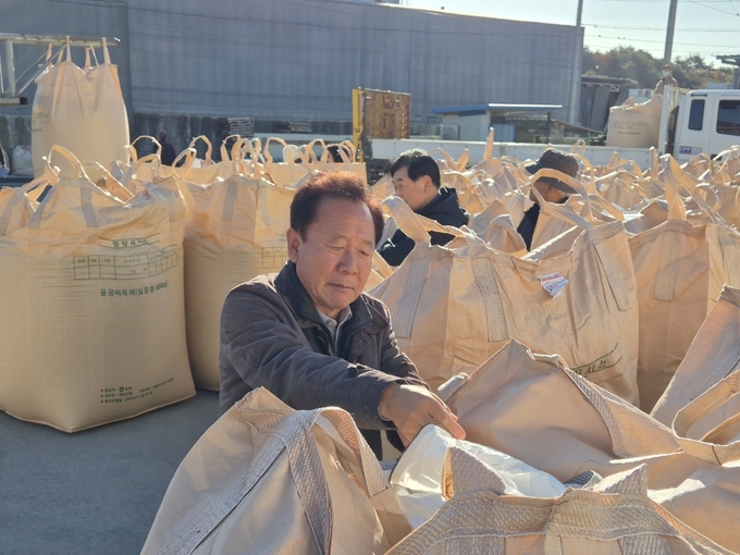 ▲ 박현국 군수가  봉화읍 유곡리 제2농공단지 임덕순 창고에서 진행된 공공비축미 매입 현장에서 출하된 2025년산 벼의 건조상태와 품질을 확인해 보고 있다.