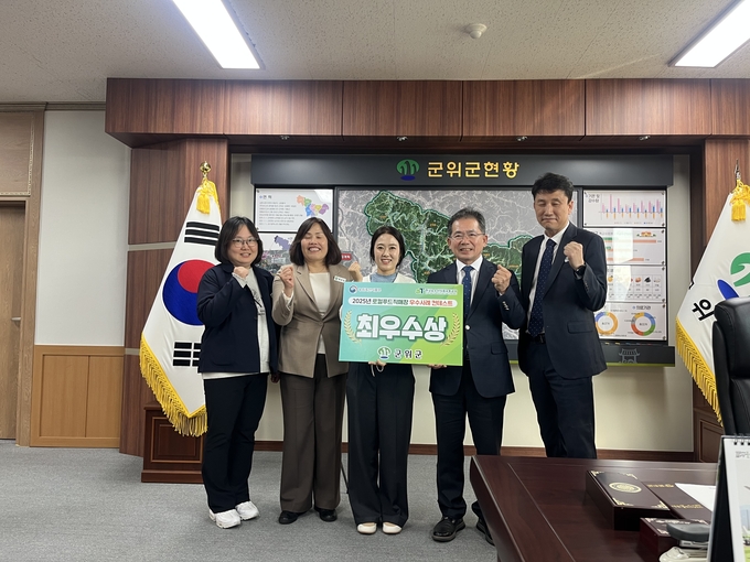 ▲ 군위군 로컬푸드 직매장 ‘장봐군위’가 2025 로컬푸드 직매장 우수사례 콘테스트 ‘최우수상’ 받았다. 김진열(오른쪽 두번째) 군위군수와 담당자들이 10월 30일 군수실에서 축하하며 기념촬영을 하고 있다. 군위군