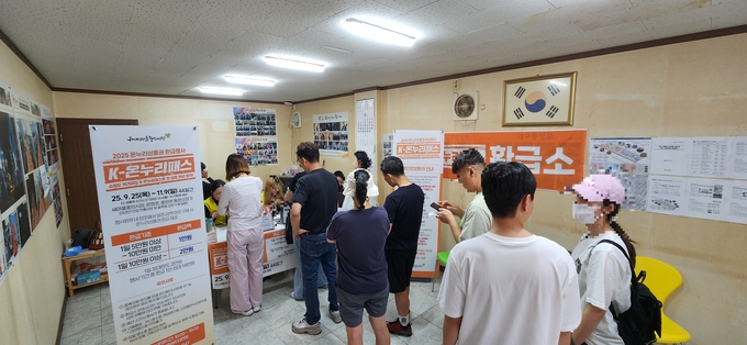 ▲ ‘2025 K-온누리패스(온누리상품권 환급)사업’에 참여한시민과 방문객들이  온누리상품권 환급소에서 줄을 서 기다리고 있는 모습.