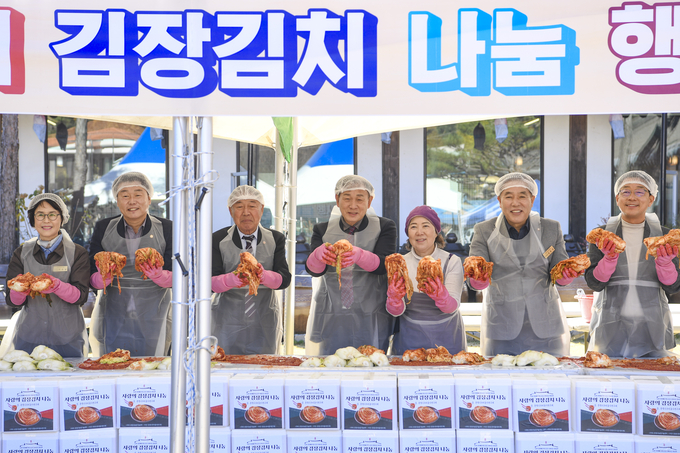 ▲ 완성된 김장김치를 들고 기념촬영을 하는 문경시우리음식연구회 회원들과 신현국 문경시장과 시의원들.