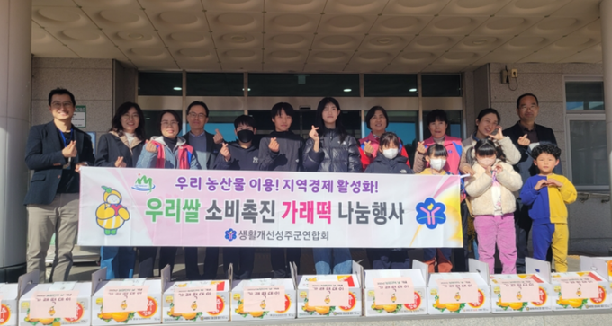 ▲ 11일 성주군농업기술센터 앞에서 열린 ‘농업인의 날 가래떡 나눔 행사’에서 생활개선성주군연합회 회원들이 성주 햅쌀로 만든 가래떡을 초등학생들에게 전달하고 있다. 성주군농업기술센터