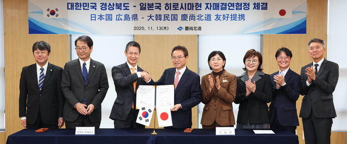 ▲ 13일 이철우( 왼쪽 4번째) 경북도지사와 유자키 히데히코(왼쪽 3번째) 히로시마현 지사가 경북도청에서 자매결연을 체결한 뒤 악수를 하고 있다.