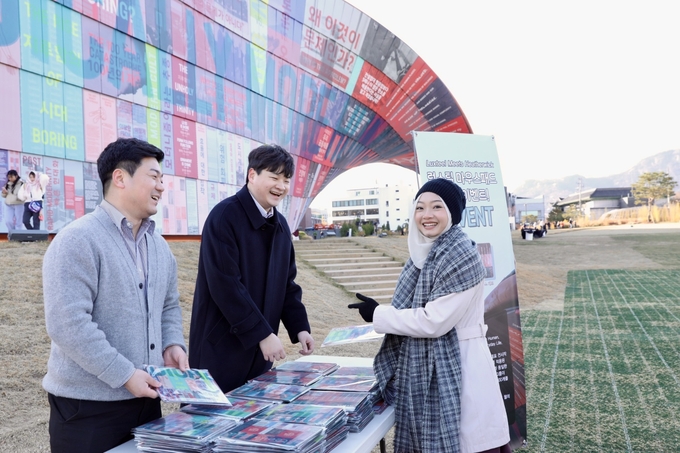 ▲ 시민이 휴머나이즈 월에서 마우스패드에 인쇄된 부분을 찾아 기념사진을 찍고 있는 모습