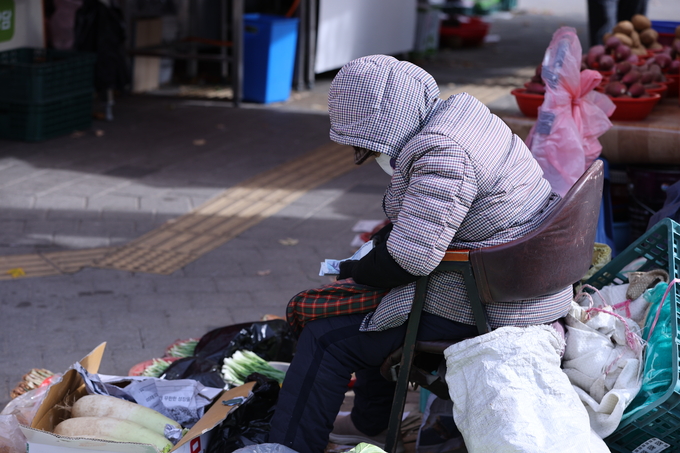 ▲ 17일 오전 기온이 낮아지고 찬 바람이 강하게 불면서 대구지역이 초겨울 날씨를 보인 가운데 대구 북구 칠성시장 한 상인이 두터운 옷차림을 하고 있다.김영환 기자yhk@kyongbuk.com