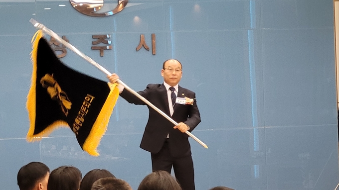 ▲ 제22기 민주평통 상주협의회 출범식이 열린 19일 정용운 신임 회장(전 더불어민주당 지역위원장)이 민주평통기를 전달받고 힘차게 흔들고 있다. 김범진기자