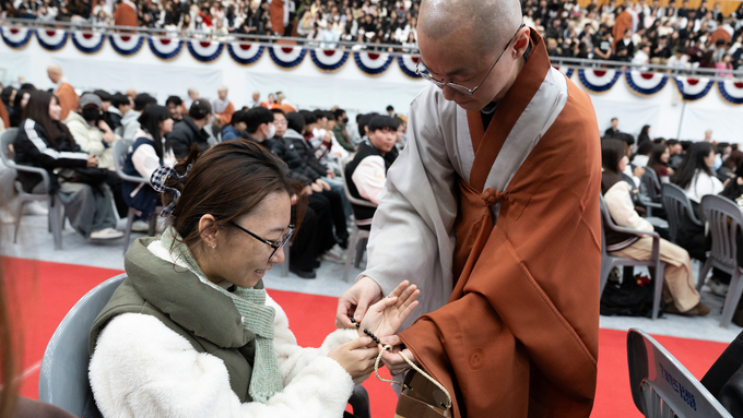 ▲ 18일 열린 ‘2025 동국대학교 WISE캠퍼스 영캠프’의 연비의식에서 한 스님이 ‘2025 영캠프’ 참여 학생에게 단주를 전달하고 있다. 동국대