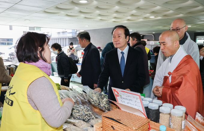 ▲ 20일 서울 종로구 조계사 직거래장터에서 김주수 의성군수(가운데)와 담화원명 주지 스님(오른쪽)이 판매 부스를 방문해 참여 농가로부터 제품 설명을 들으며 현장 소비자 반응을 직접 살펴보고 있다. 의성군