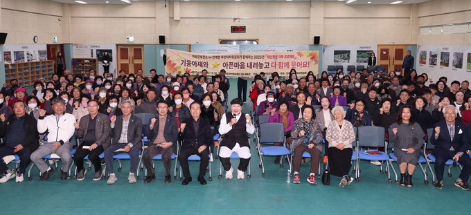 ▲ 18일 의성국민체육관에서 열린 ‘재난정신 극복 프로젝트’에서 한기웅씨(앞줄 왼쪽 일곱번째)와 김주수 군수(여섯번째)가 서부권 주민 200여 명과 함께 단상 앞 중앙에서 주먹을 들어 올리며 심리회복 프로그램의 시작을 격려하는 모습이 포착됐다. 의성군