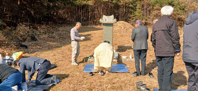 ▲ 22일 경북 의성군 봉양면 문흥리 뒷산의 성자단자 김성단 파조 묘소 앞에서 종중 참석자들이 제례 절차에 따라 헌작을 마친 뒤 묘비를 향해 절하고 제물을 정돈하는 모습이 햇빛 아래 고요하게 포착됐다. 의성김씨대동종친회