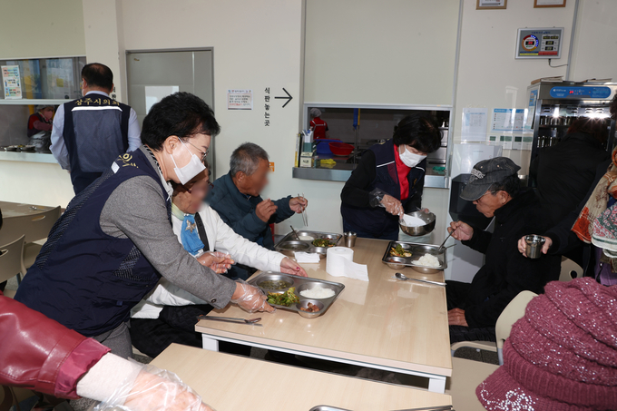 ▲ 상주시의회가 상주시 종합사회복지관에서 무료급식 봉사활동에 동참한 지난 24일 안경숙 상주시의회 의장, 이경옥 의원 등이 어르신에게 배식 봉사활동을 하고 있다. 상주시의회 제공