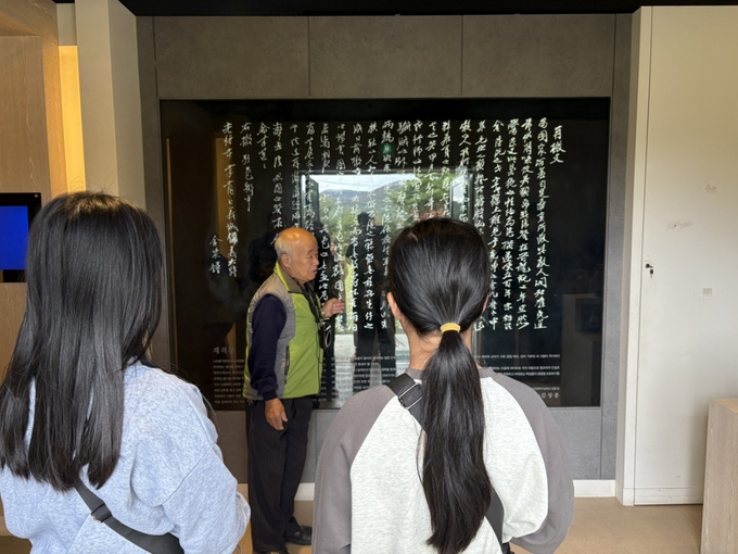 ▲ 약 8개월간 우리 고장을 직접 탐방한 활동의 하나로 의성의병관을 찾은 구천초 4학년 이겨레 학생이 문화해설사가 고문서 전시물을 가리키며 들려주는 설명을 가까이에서 집중해 듣는 장면이다. 의성교육청