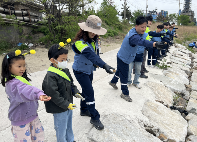 ▲ 22일 ‘퓨처엠 Nature Guard Day’ 봉사활동에 참여한 포스코퓨처엠 직원과 가족들이 씨드볼을 만들어 포항시 남구 냉천에 던지고 있다.